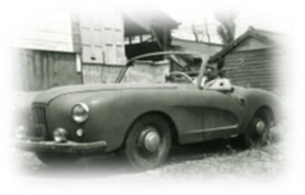 1950年代風のオープンカーとドライバーの歴史的な一枚